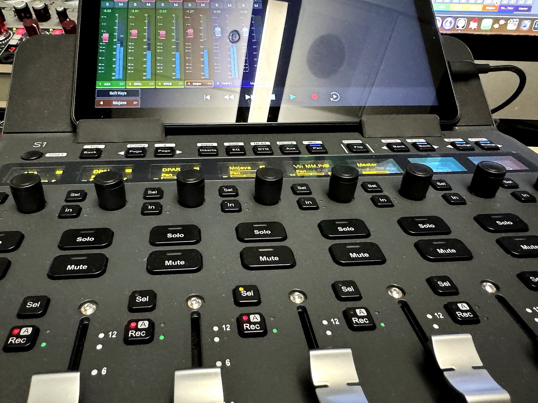 Control surface faders and mix screen in the studio